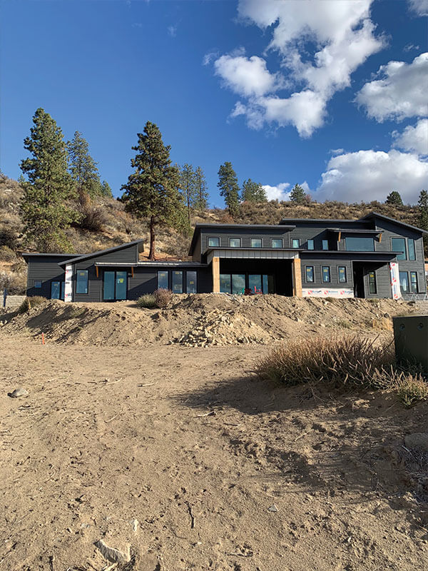 Finished modern dark-sided custom home under a wide Eastern Washington sky, built by Gitter Done Construction in Davenport