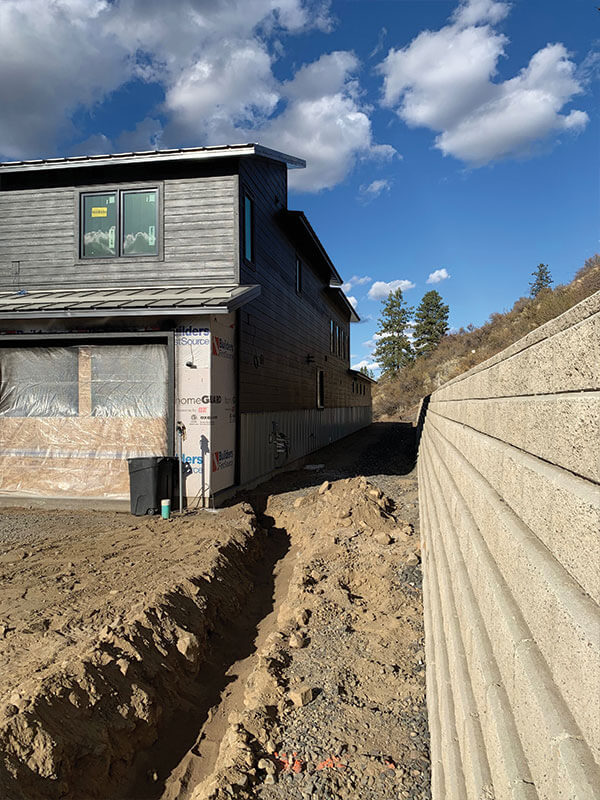 Home with concrete retaining wall and foundation drainage system installed by Gitter Done Construction in Eastern Washington
