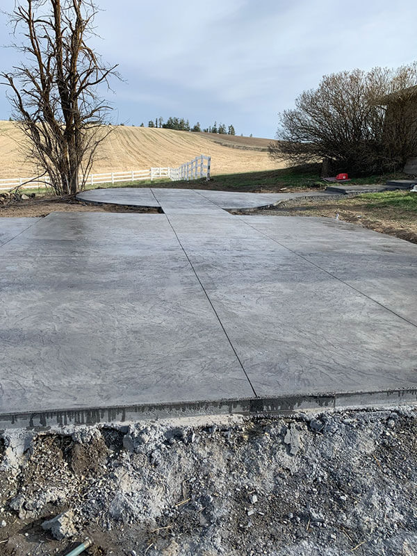 Broom-finish concrete pour with Eastern Washington wheat-field view by Gitter Done Construction in Davenport