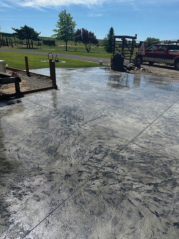 Stamped and colored concrete patio with Gitter Done Construction work truck in Eastern Washington