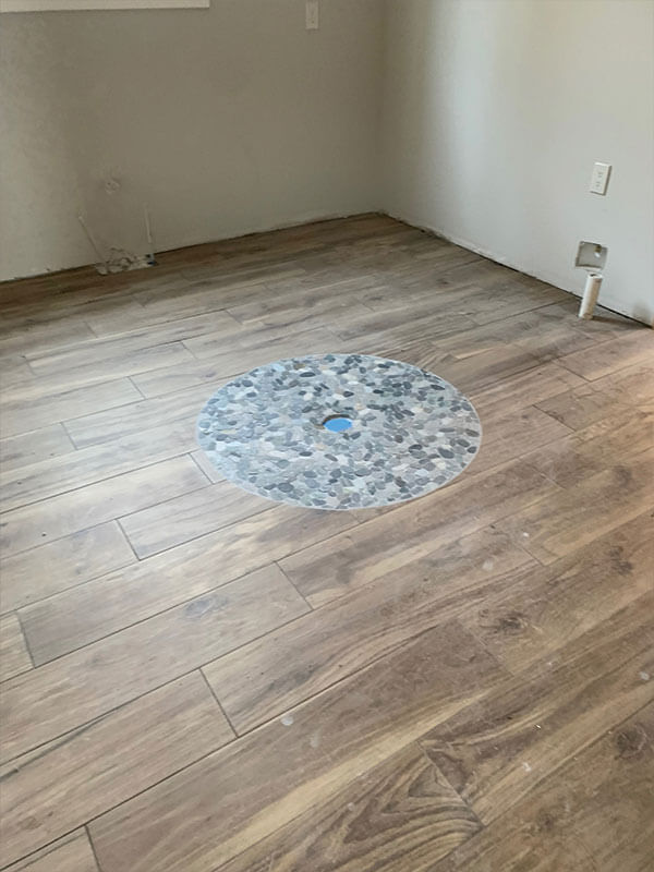 Wood-look tile floor with decorative inlay medallion installed by Gitter Done Construction