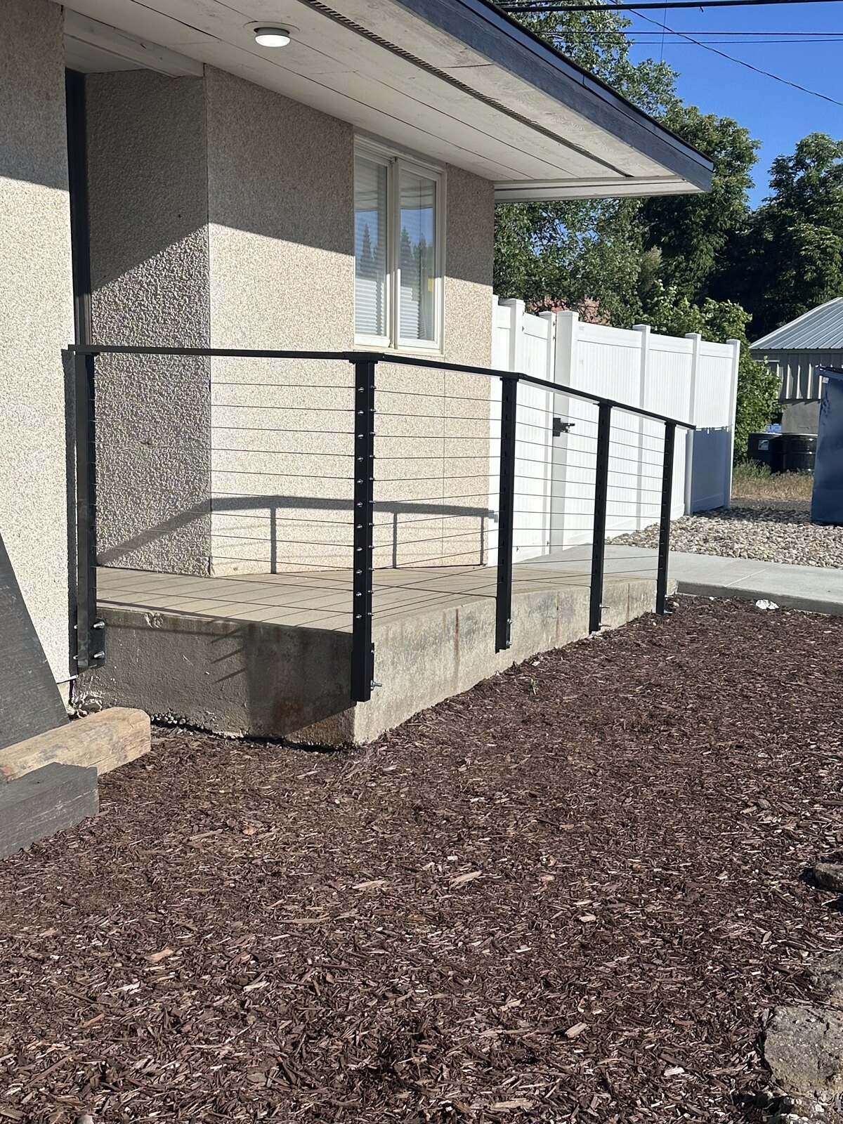 Poured concrete access ramp with black cable railing by Gitter Done Construction