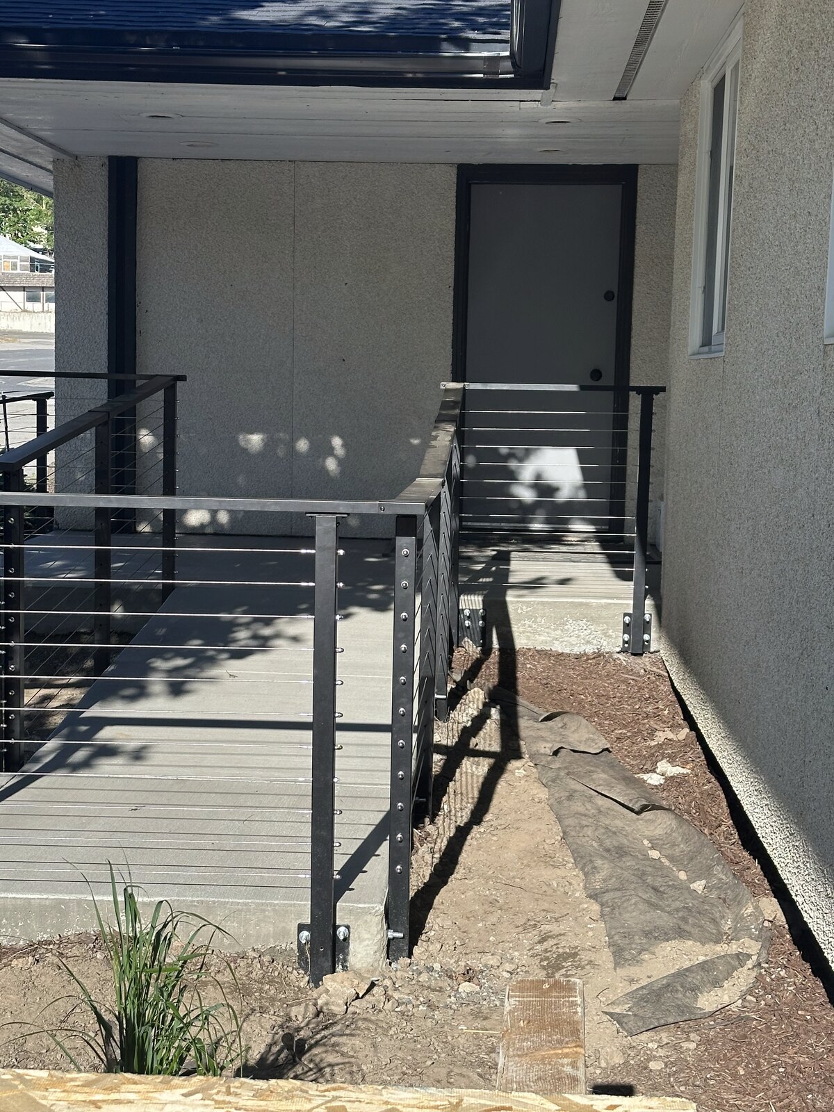 Poured concrete entry ramp and steel cable railing installed by Gitter Done Construction