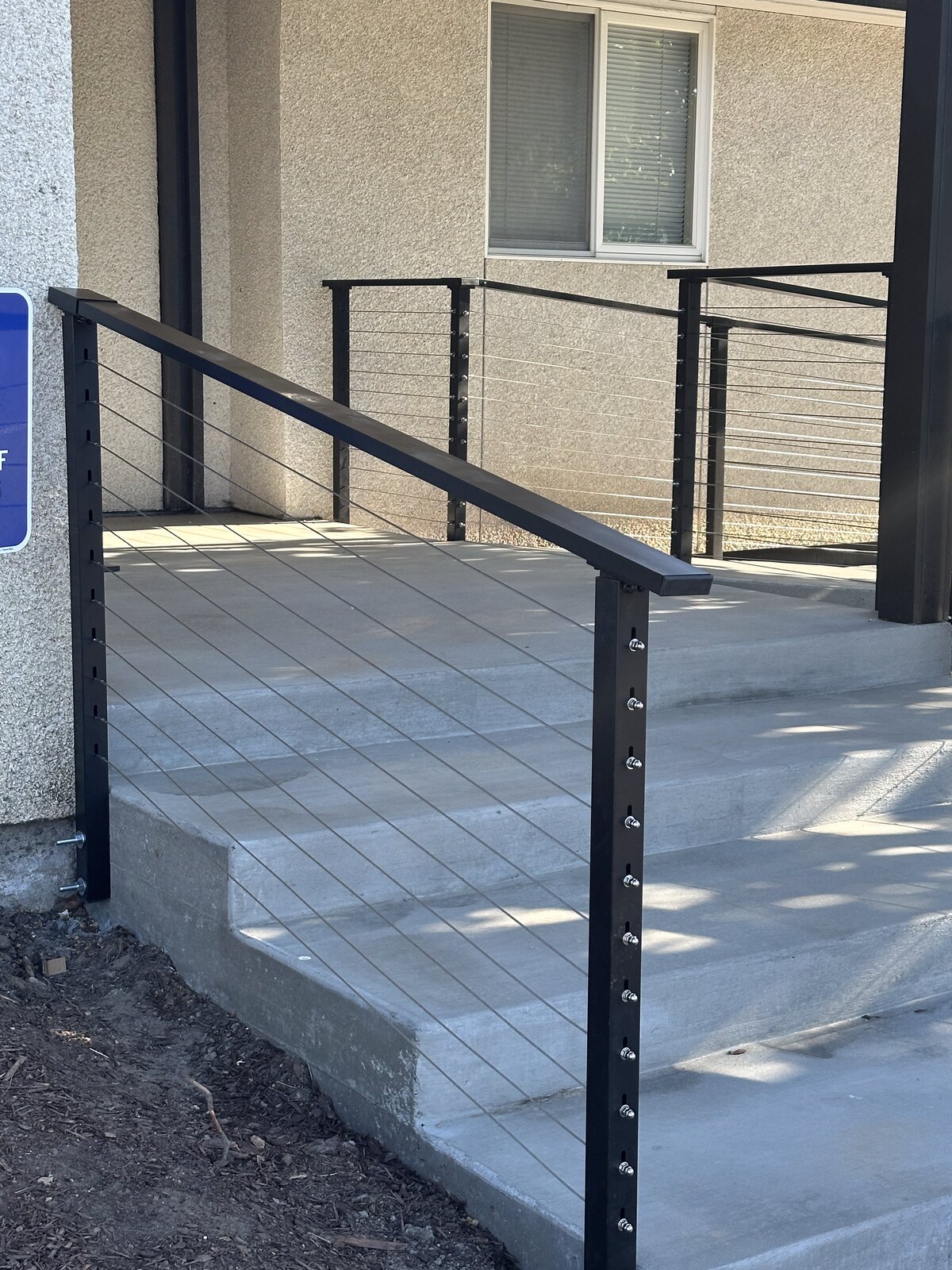 Steel cable railing installed by Gitter Done Construction on a ramp and steps